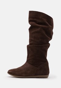 Bottes hautes jusqu'au genou en daim marron avec un design décontracté, un bout arrondi et une semelle en caoutchouc plate. Présentent une texture lisse et un minimum de ferrures.