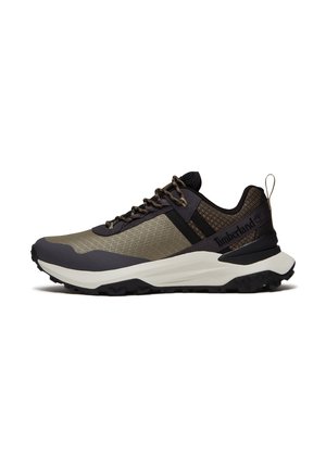 Baskets basses vert foncé et noir avec semelle blanche épaisse, dessus en mesh, fermeture à lacets et logo Timberland sur le côté.