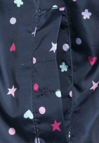 Námořnická látka s motivem barevných srdíček, hvězdiček a květin v růžové, světle modré a bílé barvě. Viditelné jsou detaily švů.