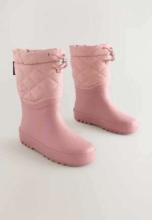Botas impermeables rosas con parte superior acolchada, parte superior ajustada y suela de goma texturizada. Superficie suave y diseño de punta redondeada.