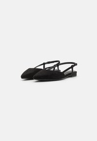 Black suede slingback flats with a pointed toe, adjustable ankle strap, and a low, stacked heel. Simple design and smooth texture.
