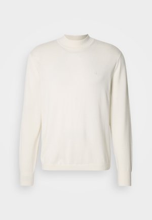 Baltas, ilgas rankoves, mezginys su išraižytu raštu, turintis aukštą apykaklę ir mažą logotipą ant krūtinės. Lygus paviršius, klasikinis siluetas.