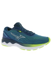 Zapato de correr con una parte superior de malla azul, acentos verdes y una suela blanca acolchada. Presenta un diseño aerodinámico y una superficie texturizada.