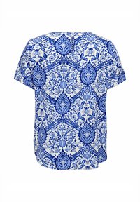 Kortärmad vit blus med ett intrikat blått blommönster och geometriskt mönster, med en liten knappstängning vid bakre halsringningen.