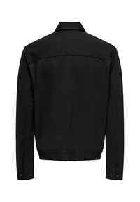 Svart jakke med lange ermer og krage, knappede mansjetter, synlig søm over øvre del av ryggen, vist bakfra på hvit bakgrunn.