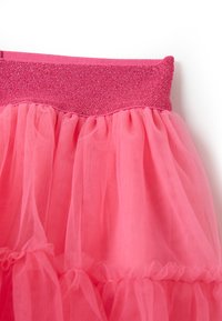 Falda de tul rosa con una cinturilla brillante rosa, volantes en capas, tejido texturizado y un acabado translúcido para un look juguetón.