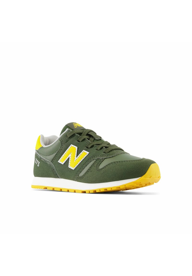 Baskets de sport vertes avec des accents jaunes, dotées d'une semelle rembourrée, d'un dessus en tissu texturé et d'un logo "N" blanc proéminent sur le côté.