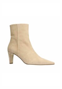 Botte de cheville en daim beige avec un bout pointu et un talon de hauteur moyenne. Texture lisse, design sans couture et silhouette subtile et épurée.