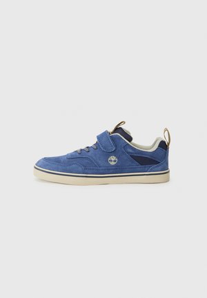 Blue suede sneaker with a padded collar, lace-up and Velcro strap closure, beige rubber sole, and contrasting navy accents. Logo displayed.