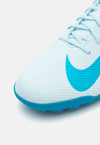 Hele sinine jalgpalliking, millel on tekstureeritud ülemine osa ja küljel suur türkiissinine Nike logo, samuti vastupidav kummist välistald sama värviga.