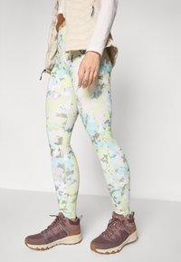 Leggings i lyse pastel-farver med et abstrakt camo-mønster. Akkompagneret af brune vandrestøvler med struktureret stof og holdbare såler.