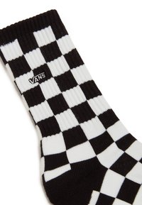 Calze a scacchi in bianco e nero con texture a coste, dotate di un piccolo logo Vans nero sul lato.