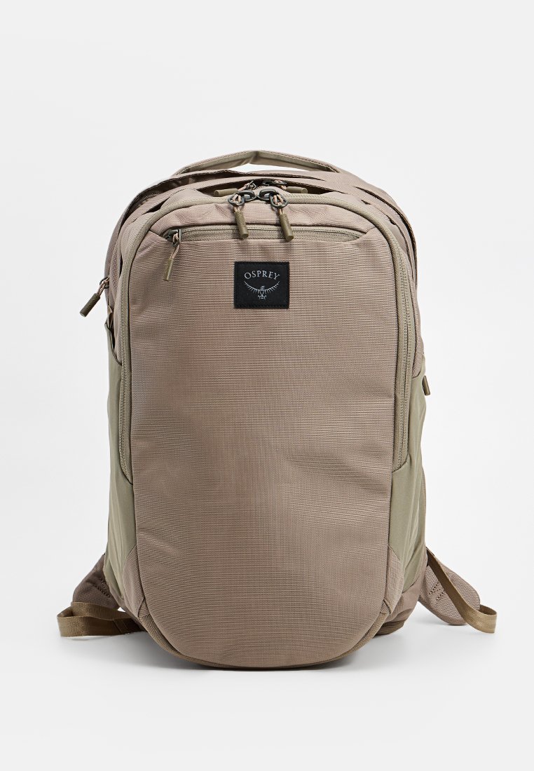 Osprey backpack in beige and olive green, featuring a textured fabric, dual zippers, a logo patch, and adjustable padded straps.
