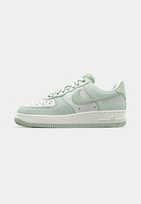 Jasnozielone zamszowe sneakersy z białymi skórzanymi akcentami, perforowana osłona na palce, płaskie sznurowadła i teksturowana gumowa podeszwa z logo "AIR".