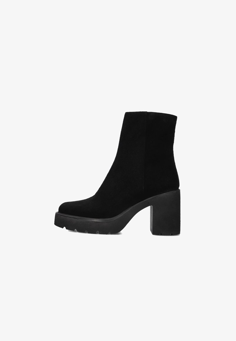 Bottines en suède noir avec une plateforme épaisse et un talon carré. Elles présentent une texture lisse et un design minimaliste. Silhouette élégante.