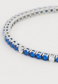 Kék és áttetsző, kerek drágakövekből álló karkötő, ezüstszínű fémből készült láncszemes kialakítással, váltakozó kék és áttetsző kövekkel.