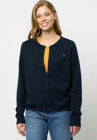 Cardigan bleumarin cu mâneci lungi, decolteu rotund și închidere cu nasture. Prezintă un mic detaliu brodat pe pieptul stâng.