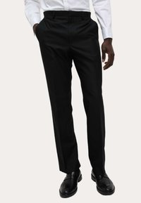 Czarne formalne spodnie o prostym kroju, gładki materiał, plisowany przód i klasyczny pas, w połączeniu z czarnymi eleganckimi butami.