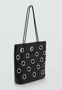 Bolso tote negro con diseño plano, adornado con múltiples ojales de plata y dos correas largas para el hombro. Fabricado con tejido suave.