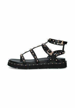 Sandalo basso nero stile gladiatore con borchie dorate, tre fibbie regolabili e suola spessa.