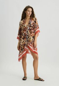 Chiffon kimono met een dierenprint in bruin- en crèmekleuren, met rode gestreepte accenten langs de zoom en mouwen. Licht en vloeiend ontwerp.