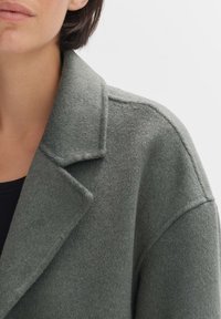 Grau melierter Wolle-Mix-Mantel mit Reverskragen, strukturiertem Stoff und einer lässigen Silhouette, die auf Einfachheit im Design setzt.