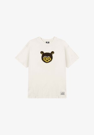 Cremefarbener Baumwoll-T-Shirt mit einem Braunbären-Gesichtdesign auf der Vorderseite. Kurze Ärmel, Rundhalsausschnitt und ein kleines Markenetikett unten links.