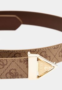 Cintura in tessuto marrone con un design testurizzato, dotata di una fibbia triangolare in tonalità oro che mostra il logo "GUESS".