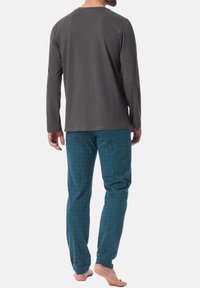 Men's loungewear set featuring a gray long-sleeve top and teal patterned pants. The fabric appears soft with a relaxed fit and subtle textures.