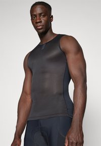 Schwarzes sportliches Tanktop mit einem strukturierten, körperbetonten Design. Verfügt über einen runden Ausschnitt und minimale Nahtdetails, geeignet für sportliche Aktivitäten.