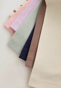 Stacked folded fabric pieces in beige, brown, navy, light green, lavender, pink, and striped pattern with visible stitching details.