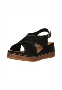 Sandale compensée en daim noir avec des brides croisées, bout ouvert, semelle en liège marron et boucle ajustable à la cheville.