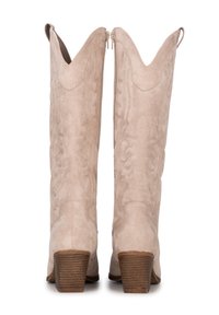 Botas de vaquero de ante crema con un patrón de costura decorativo, caña alta, puntas en forma de flecha y un tacón de madera apilado. Cremalleras laterales para facilitar su uso.