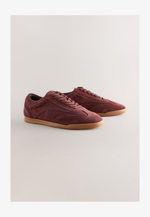 Bordeauxfarvede ruskinds-sneakers med rundet tå, gummisål og diskrete syningsdetaljer. Snørebånd og et lavprofildesign fuldender looket.