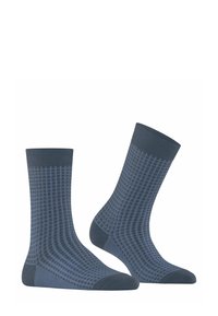 Calzini blu scuro con un motivo a griglia in blu più chiaro. Texture a coste nella parte superiore; finitura liscia sul corpo. Design alla caviglia.