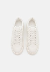 Hvite lær sneakers med rund tå, flate snørebånd og minimalistisk design. Har subtile merkevarer og teksturerte detaljer på sidene.