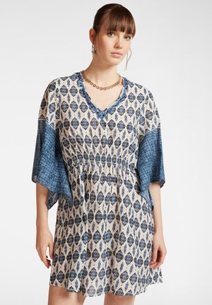 Vestido de manga corta, hasta la rodilla, en color crema con un patrón floral azul. Presenta una cintura fruncida y mangas de patrón azul contrastante.