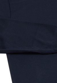 Maglione in lana blu navy, maniche lunghe con polsini a coste, texture liscia e leggero lucido. Presenta un classico collo a giro e un design aderente.
