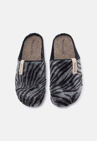 Fekete és szürke zebra mintájú műszőrme papucsok, puha felsőrésszel és oldalukon márkanévvel ellátott bézs címkével.