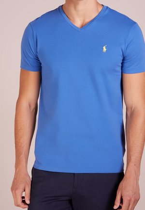 T-shirt bleu à col en V en tissu mélangé de coton doux. Dotée de manches courtes et d'un petit logo polo jaune sur la poitrine gauche.