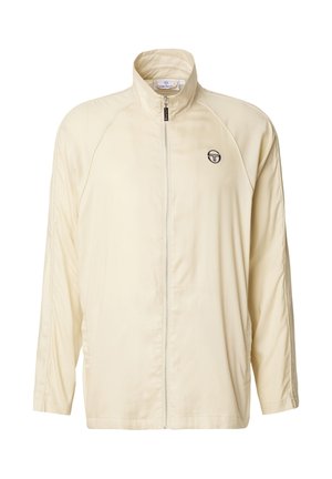 Kreemikas pikkade varrukatega spordijakk, millel on täielik eesmine lukustus ja vasakul rinnal väike must logo.