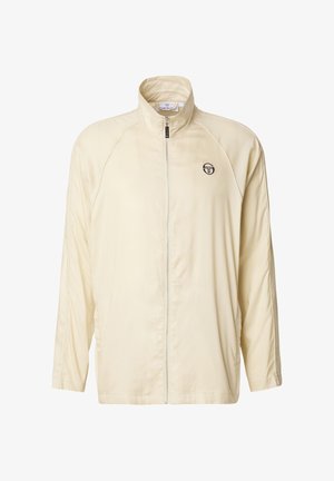 Kreemikas pikkade varrukatega spordijakk, millel on täielik eesmine lukustus ja vasakul rinnal väike must logo.