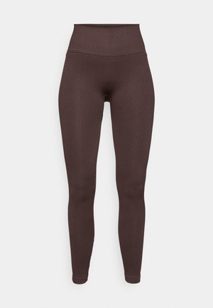 Leggings castanhos canelados com uma cinta alta, feitas de tecido elástico, apresentando uma textura suave e um design que se ajusta ao corpo.