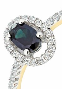 Sidabrinis žiedas su ovaliu tamsiu akmeniu, apsuptu mažų skaidrių akmenėlių, ir sukta juosta su auksiniais akcentais.