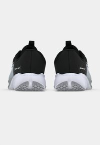 Fekete és szürke sportcipők texturált felsőrésszel, saroknál húzófüllel és fehér gumitalppal, amelyen bordázott minta található.