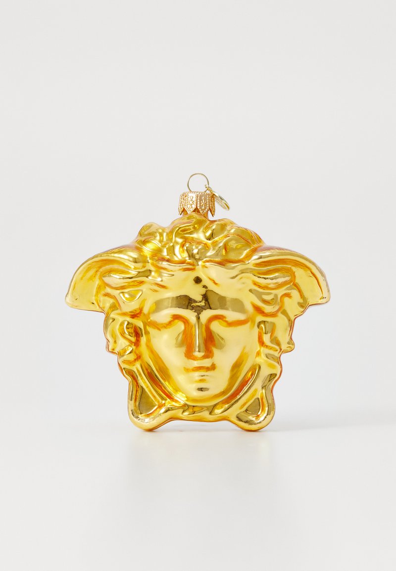 Goldene Glasornament in Form eines Kopfes mit welligem Haar, glänzender Oberfläche und einer Schlaufe zum Aufhängen. Die Details umfassen Gesichtszüge und ein kunstvolles Design.