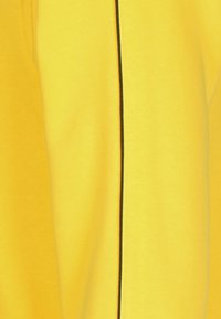 Heldere gele stof met een gladde textuur, met een contrasterende zwarte verticale naad. Het design heeft een casual, eenvoudige vorm.