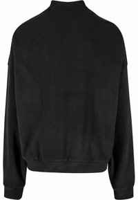 Svart fleece-genser med høy krage, falleksler og ribbet kant. Teksturen er myk, med en jevn overflate og uten synlige mønstre.