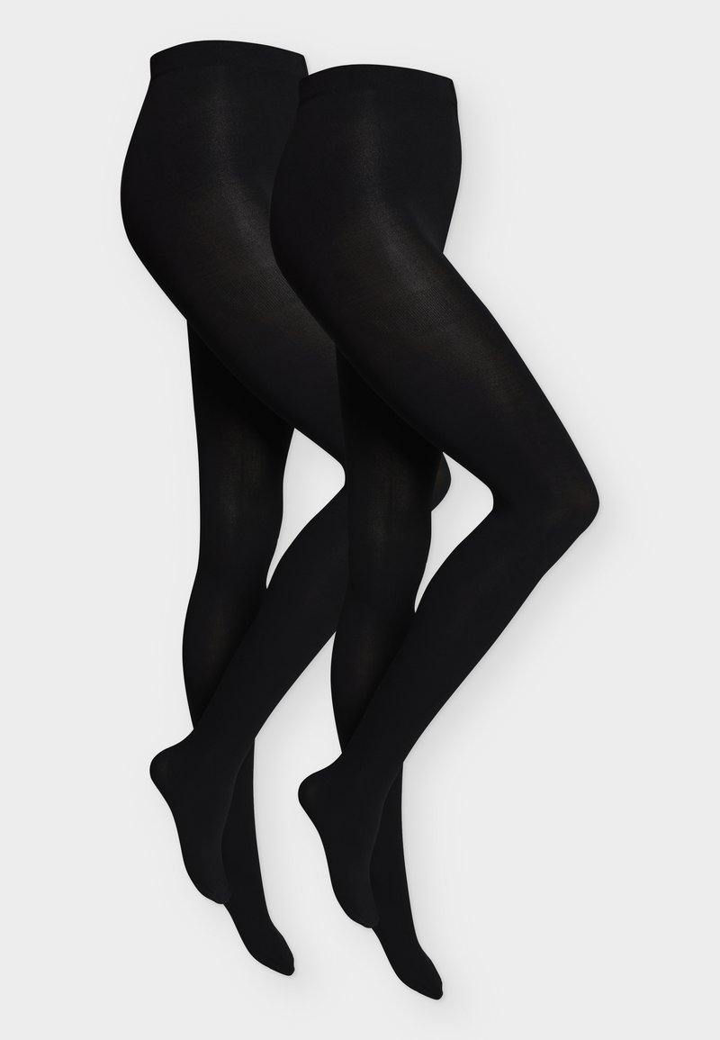 Deux paires de collants noirs opaques présentées côte à côte sur un fond clair et uni, jambes croisées aux chevilles.