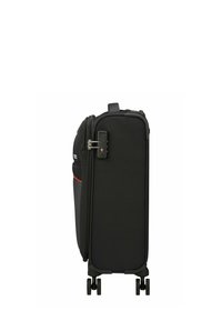 Valise noire à roulettes avec coque rigide, munie d'une serrure à combinaison, d'une fermeture éclair lisse, d'une bande accent rouge et de quatre roues pivotantes.